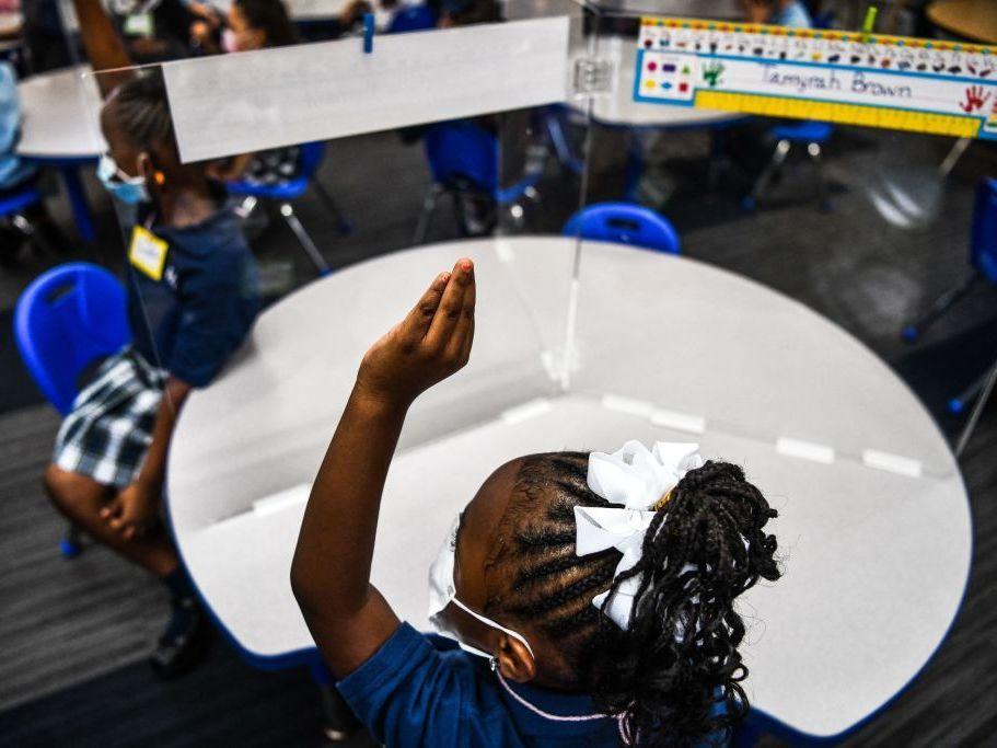 Student wear facemasks as they attend their first day in school after summer vacation at the St. Lawrence Catholic School north of Miami on Wednesday.