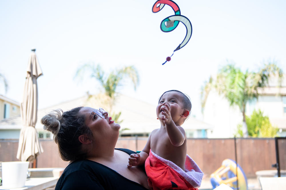 Alysha Johnson holds her now-healthy son, River, at their home in Discovery Bay, Calif. After the toddler got quite sick after a play date, his mom, aunt and her boyfriend, who'd all been vaccinated, caught what Johnson says felt 