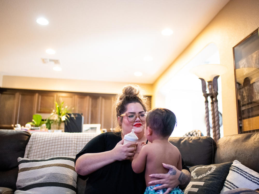Johnson gives River a bottle in her home in Discovery Bay. Family members spent isolation together there this summer, after getting sick with COVID-19. Everyone has since recovered.