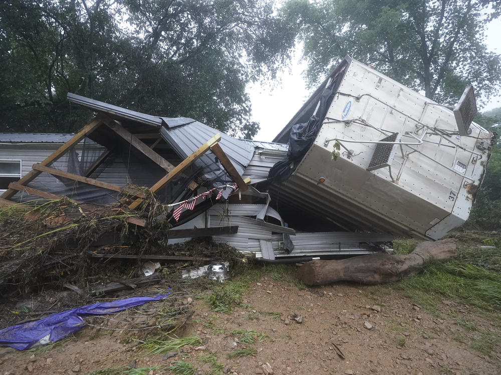 A mobile home and a truck trailer sit near a creek Sunday after they were washed away by flood waters the day before in McEwen, Tenn. Heavy rains caused flooding in middle Tennessee and have resulted in multiple deaths as homes and rural roads were washed away.
