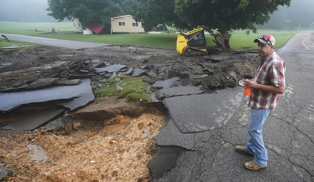 Michael Pate watches as a road is repaired on Sunday in McEwen, Tenn. Pate repaired the road Saturday after heavy rain washed part of it away, but the road was damaged again when more rain fell Saturday night. Heavy rains caused flooding in Middle Tennessee and have resulted in multiple deaths as homes and rural roads were washed away.