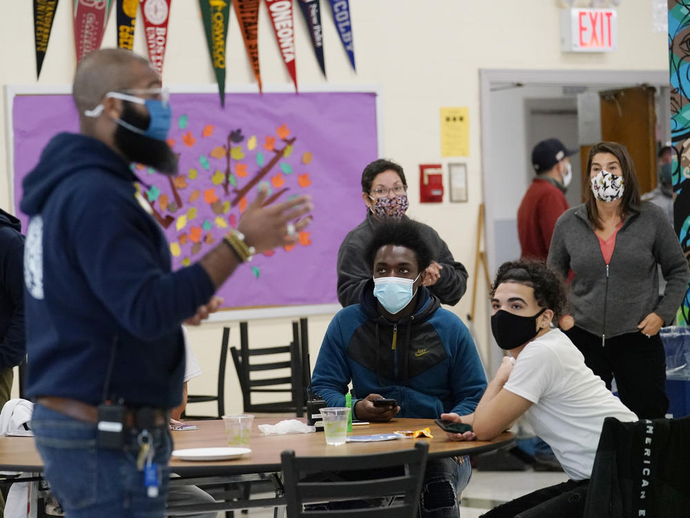 Principal Malik Lewis, second from left, is pictured at West Brooklyn Community High School in New York City in October 2020. All New York City public school teachers and other staffers will have to get vaccinated against the coronavirus, officials said Monday, as the nation's largest school system prepares for classes to start next month.