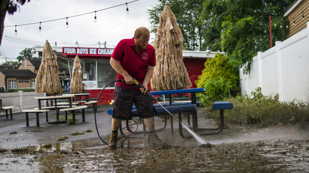 A worker cleans the outside area of Four Boys Ice Cream store after Tropical Storm Henri in Jamesburg, N.J., on Monday.