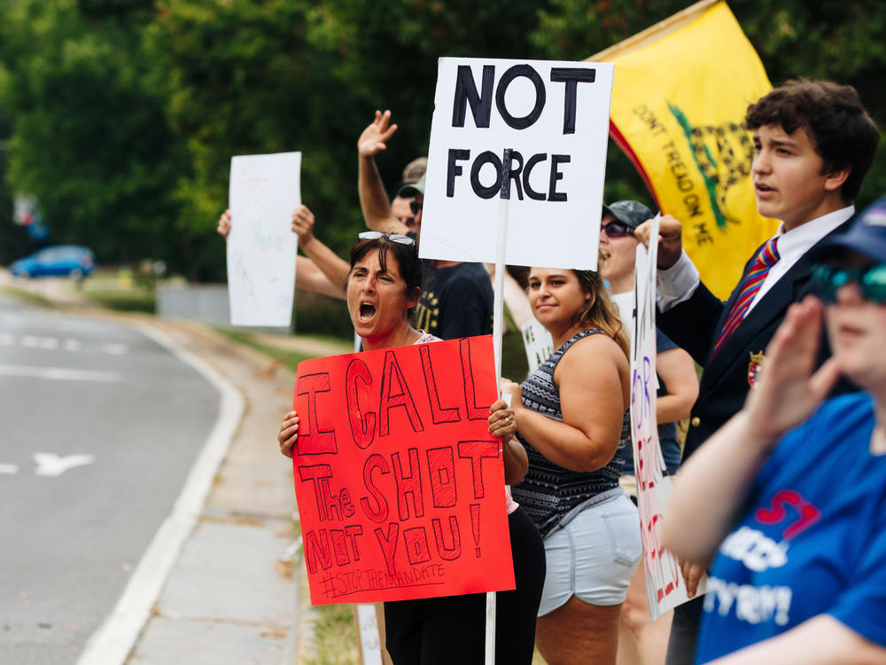 Misty Cunningham yells at a passing motorist outside Winchester Medical Center on Aug. 10 in Winchester, Va. Health care workers went on strike over a COVID-19 vaccine mandate by their employer Valley Health.