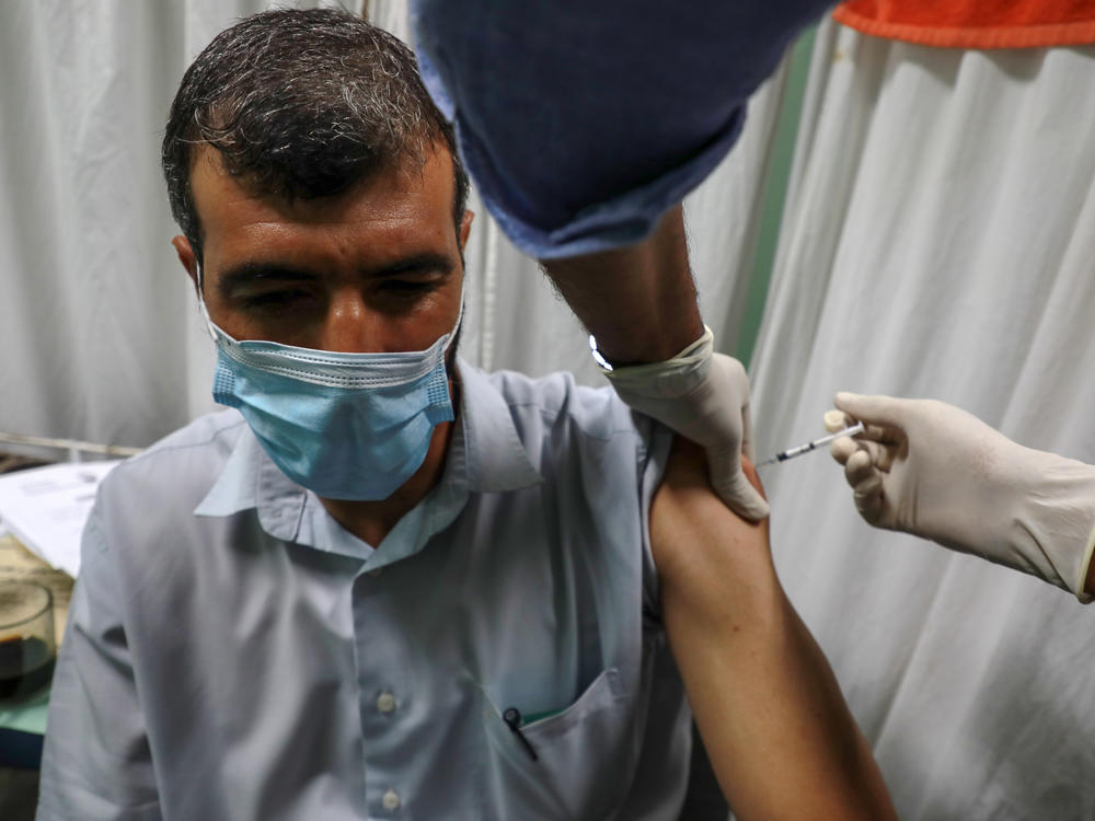 A Palestinian medic administers a dose of the Pfizer-BioNTech COVID vaccine during an inoculation campaign at a medical center in Gaza City on Aug. 23.