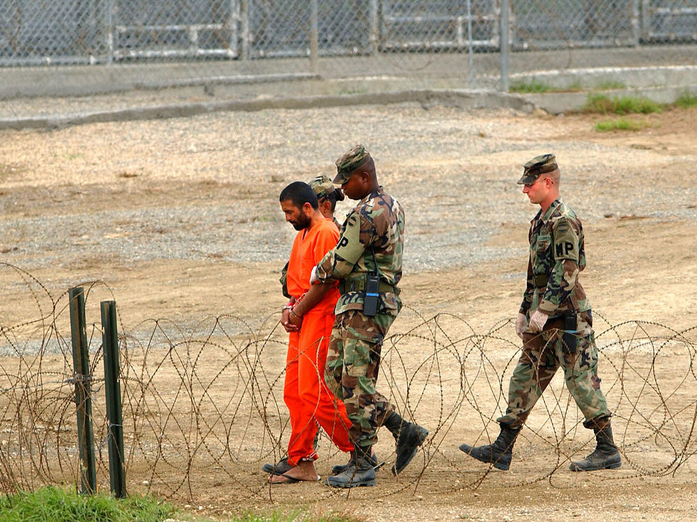 Marines transport a detainee in Guantánamo Bay, Cuba, in 2002. Nearly 800 detainees have passed through the prison since it opened that year. Today, 39 men are still being held there.