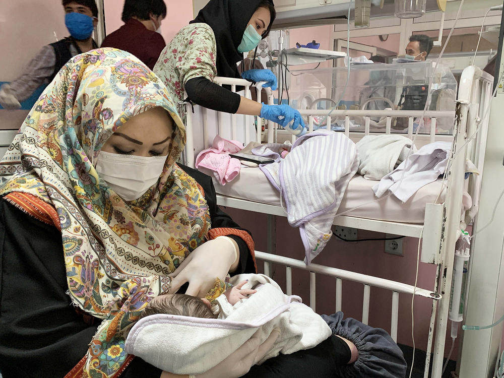 An Afghan woman feeds a newborn rescued and brought to Ataturk National Children's Hospital in Kabul in May 2020 after gunmen attacked a maternity ward operated by Doctors Without Borders. The nonprofit runs clinics and hospitals in parts of the country — and is continuing its work following the Taliban takeover.