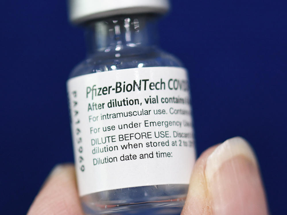 A nurse holds a vial containing the Pfizer-BioNTech COVID-19 vaccine at a mobile vaccination site.