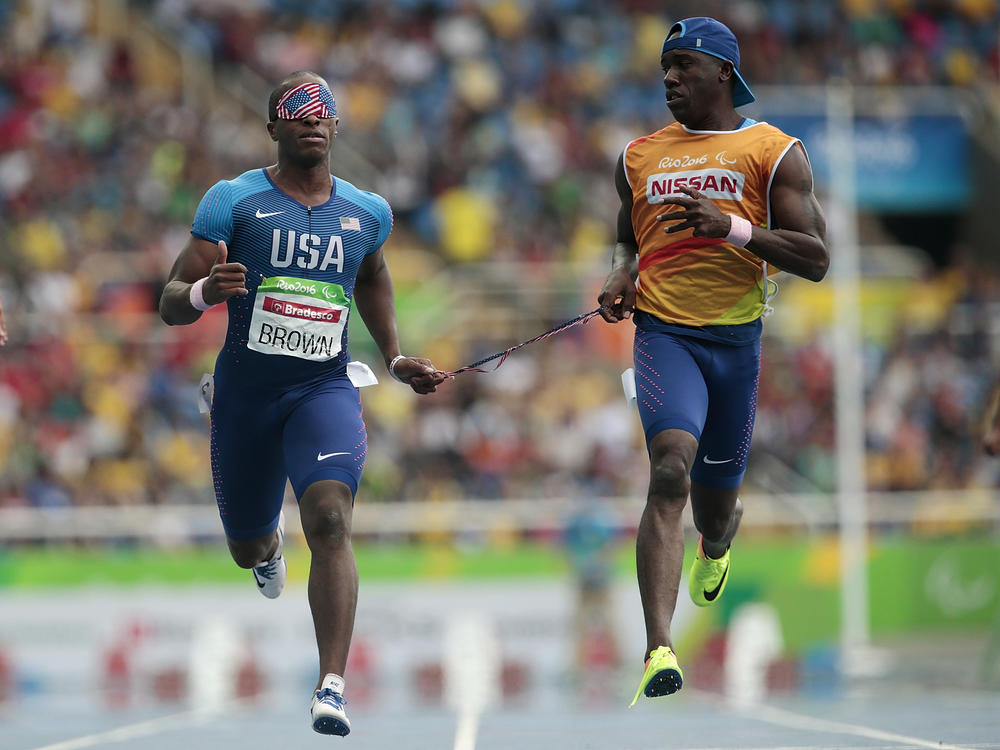 David Brown (left) runs the men's 100 meter T11 round 1 on day 3 of the Rio 2016 Paralympic Games on September 10, 2016 in Rio de Janeiro, Brazil. He is competing in Tokyo with a new partner, Moray Steward.