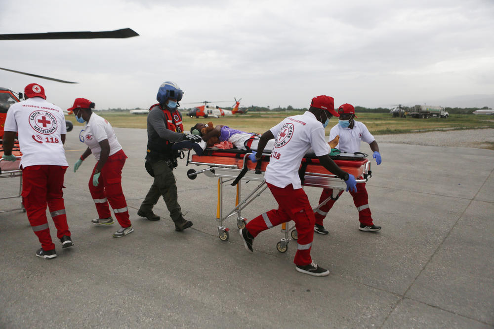 The U.S. Coast Guard and the Haitian Red Cross transport a patient to a tent hospital to be treated for their injuries sustained in the recent 7.2 magnitude earthquake, at the Toussaint Louverture International Airport, in Port-Au-Prince on Wednesday.