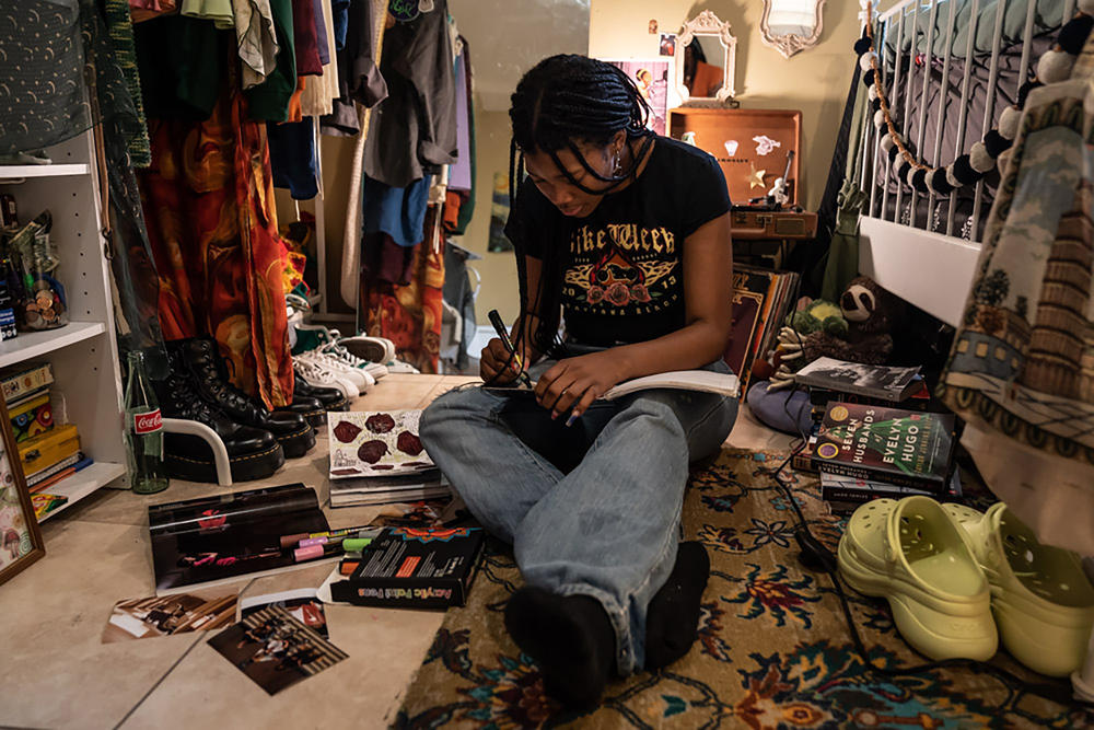 Makiyah Hicks, sits in her bedroom where she recorded her part of the podcast 