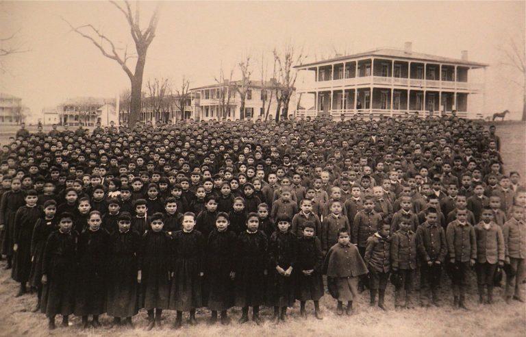 The students of the Carlisle Indian School are amassed on the grounds of the school in March of 1892.