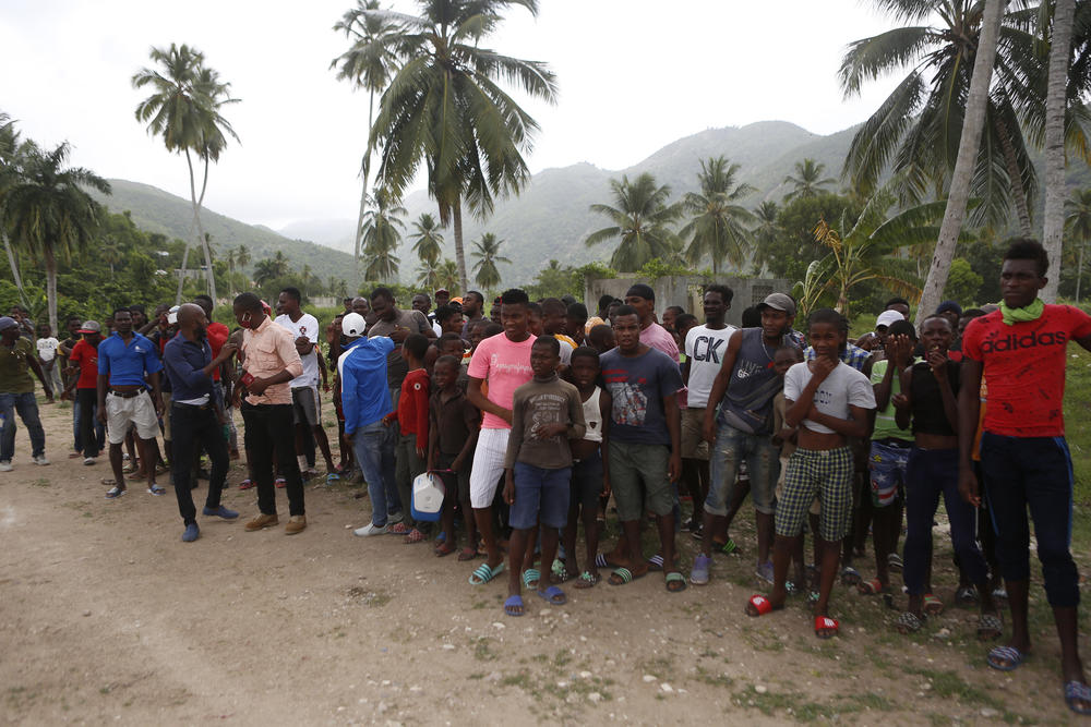 Families wait to receive humanitarian aid from a U.S. Army helicopter unit in the town of Baradères, Haiti, on Wednesday.