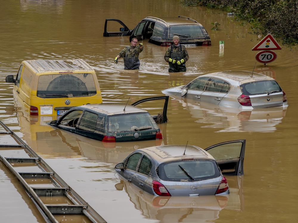 People check for victims in flooded cars on a road in Erftstadt, Germany, on July 17 following heavy rainfall that broke the banks of the Erft river, causing massive damage.
