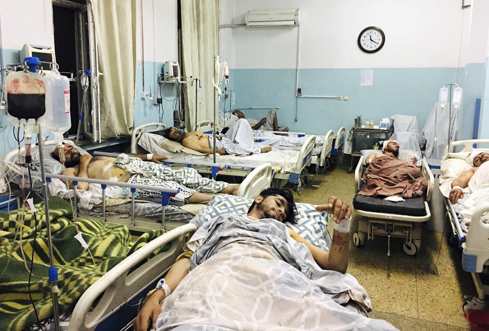 <strong>Thurs., Aug. 26: </strong>Afghans lie on beds at a hospital after they were wounded in the deadly attacks.