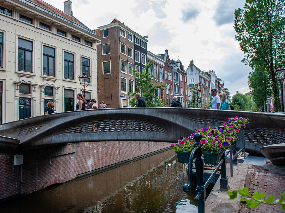 The almost 40-foot 3D-printed pedestrian bridge designed by Joris Laarman and built by Dutch robotics company MX3D has been opened in Amsterdam six years after the project was launched. The bridge, which was fabricated from stainless steel rods by six-axis robotic arms equipped with welding gear, spans the Oudezijds Achterburgwal in Amsterdam's Red Light District.