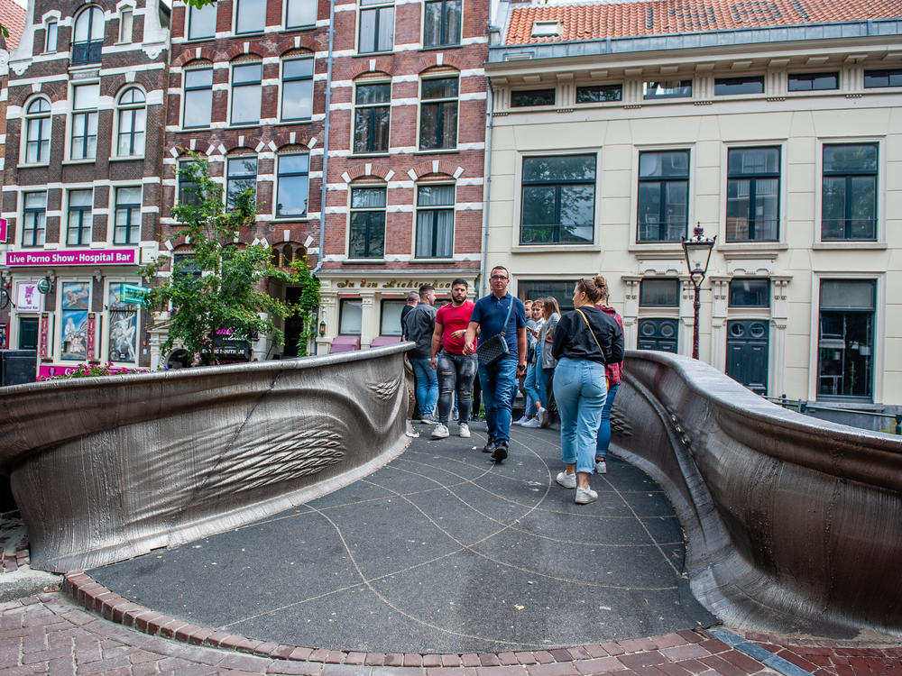 A 12-meter 3D-printed pedestrian bridge designed by Joris Laarman and built by Dutch robotics company MX3D has been opened in Amsterdam six years after the project was launched.