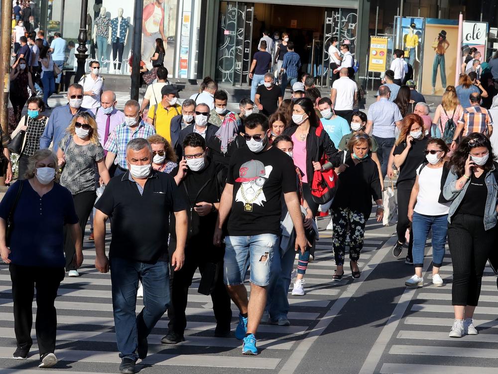 People don face masks to help keep the coronavirus at bay in June in Ankara, Turkey. But what about earlier recommendations to stay 6 feet away from others and limit close contact to 15 minutes? Are these still effective against the contagious delta variant?