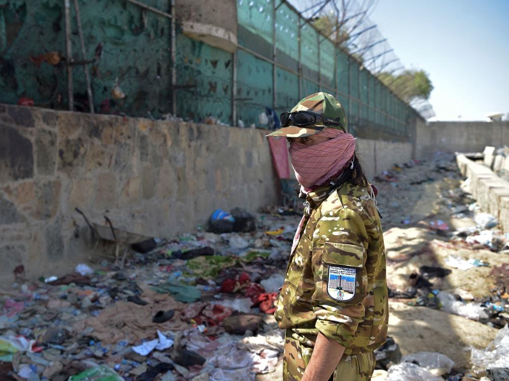 A Taliban fighter stands guard Friday at the site of the bombing that killed scores of people, including 13 U.S. troops, near the airport in Kabul. The U.S. is blaming ISIS-K for Thursday's attack.