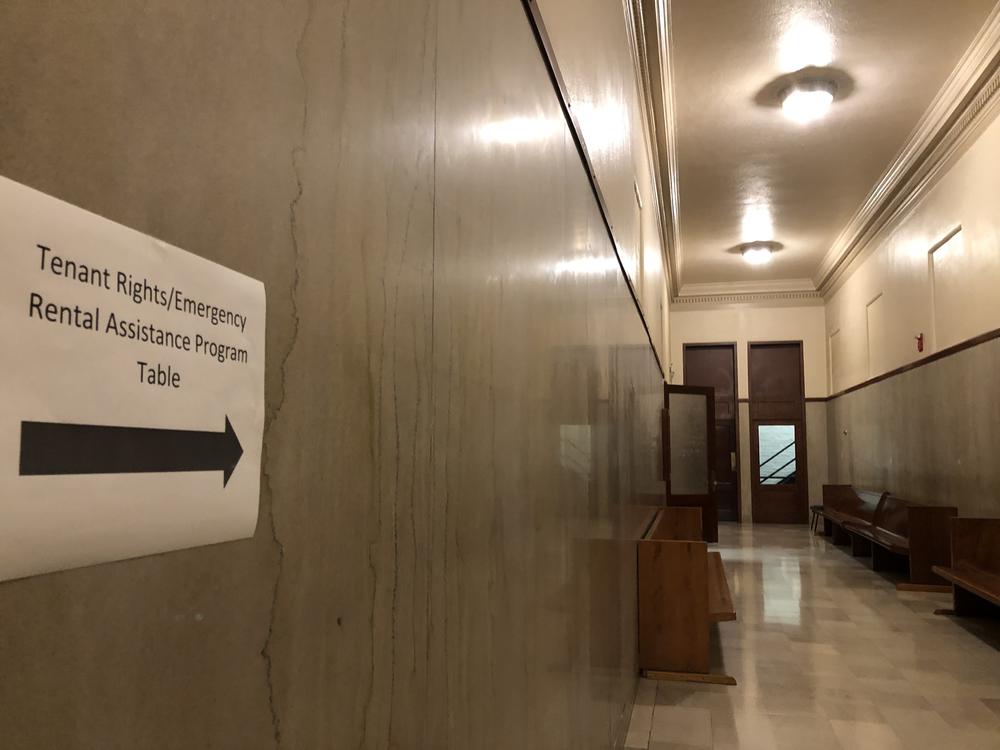 A sign at the courthouse points to the room where tenants can get help applying for rental assistance.