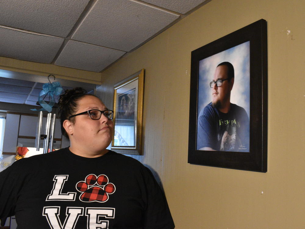 Stephanie Rimel looks at a photo of her brother Kyle Dixon, 27, who died of COVID-19 on Jan. 20. She says that during his illness and after his death, some people made insensitive comments or denied the pandemic's reality.