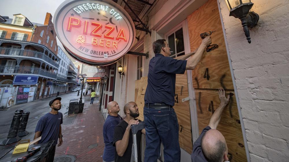 Michael Richard of Creole Cuisine Restaurant Concepts boards up Crescent City Pizza on Bourbon Street in the French Quarter before landfall of Hurricane Ida in New Orleans, on Saturday. Richard said the group is planning to board up and protect 34 restaurants owned by the company for the storm.