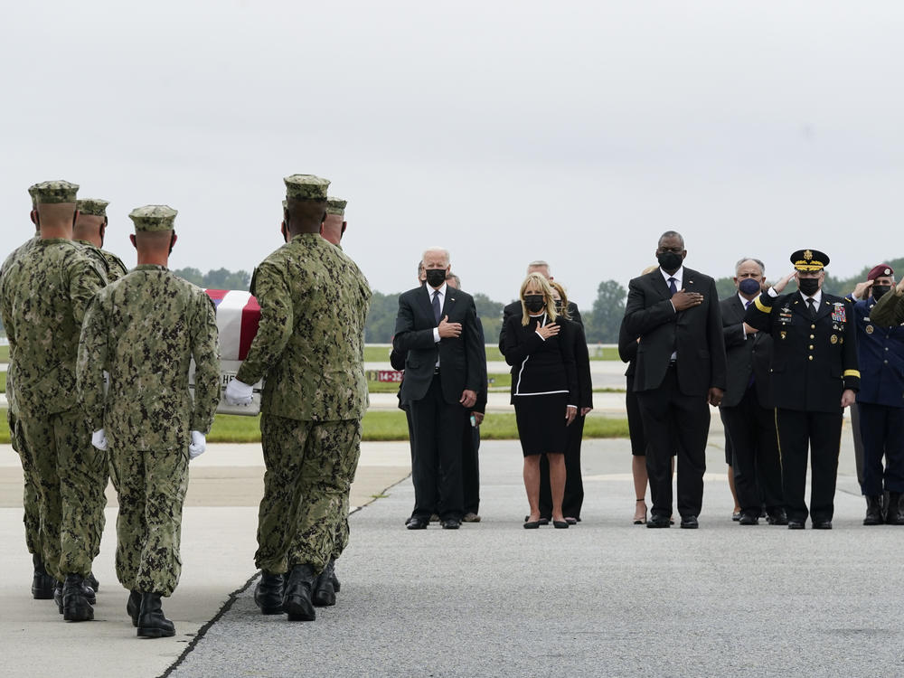 President Joe Biden watches as a Navy carry team moves a transfer case containing the remains of Navy Corpsman Maxton W. Soviak, 22, of Berlin Heights, Ohio, Sunday, Aug. 29, 2021, at Dover Air Force Base, Del.  (AP Photo/Manuel Balce Ceneta)