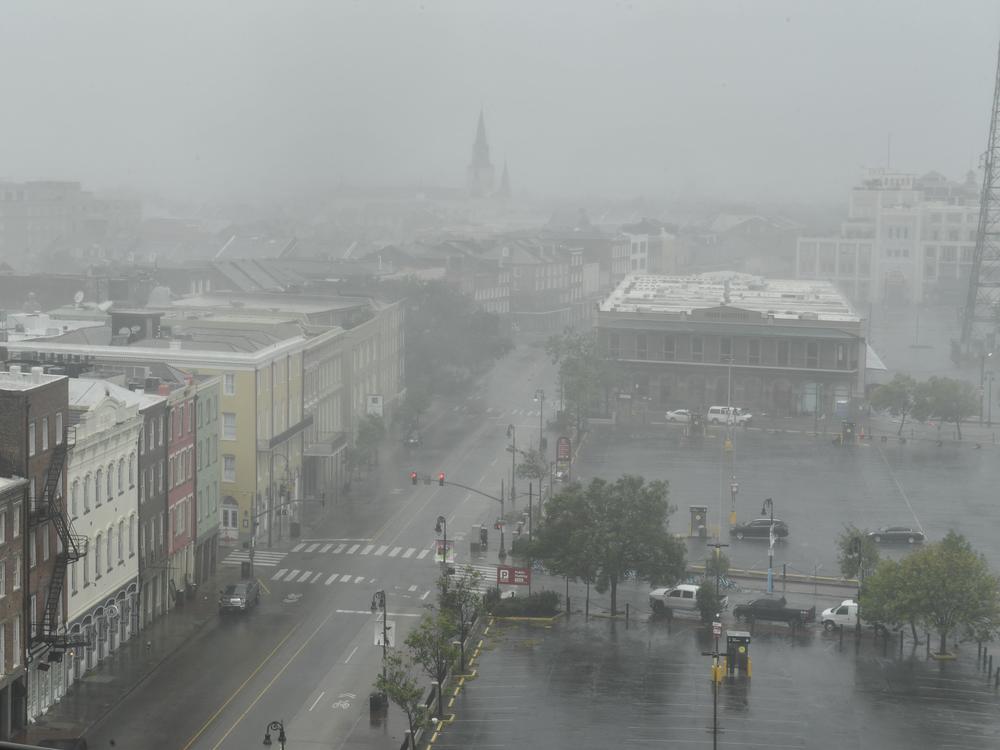 Rain batters N. Peters Street in New Orleans with St. Louis Cathedral visible in the distance on Sunday.