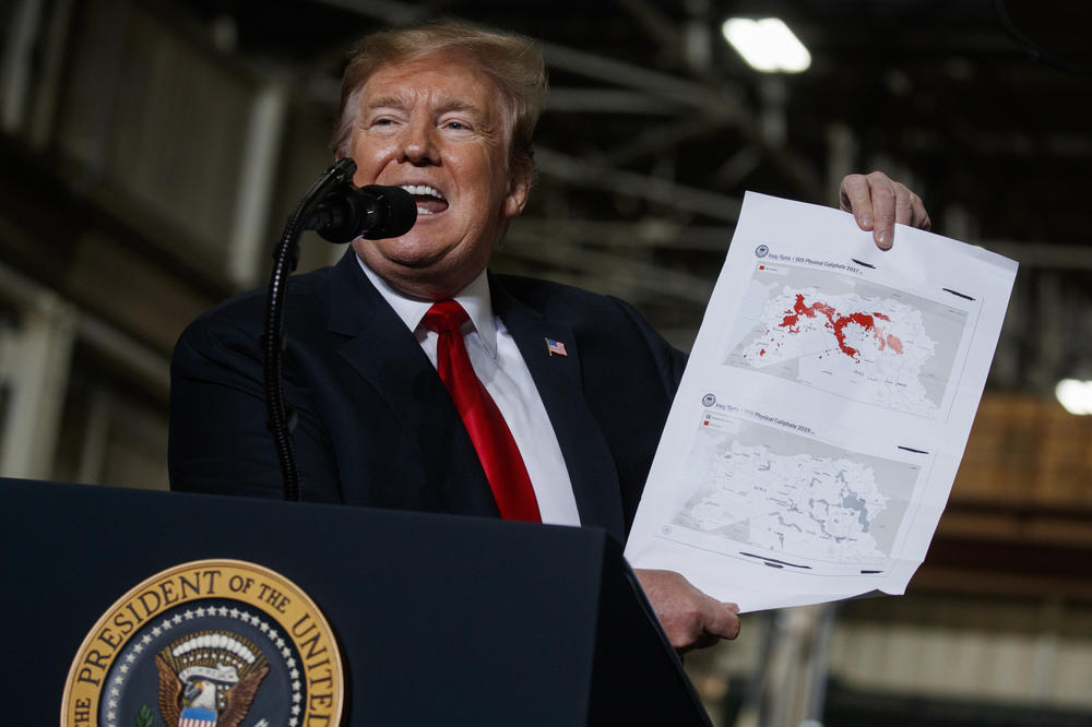 President Donald Trump holds up a chart documenting ISIS land loss in Iraq and Syria as delivers remarks at the Lima Army Tank Plant on March 20, 2019, in Lima, Ohio.