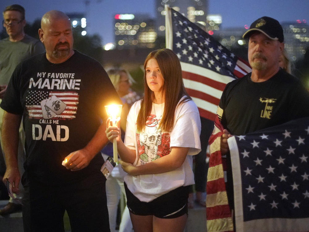 Sydney Robison, center, looks on during a vigil for U.S. Marines Staff Sgt. Taylor Hoover Sunday in Salt Lake City. Hoover was among the 13 U.S. troops killed in a suicide bombing at Kabul airport.