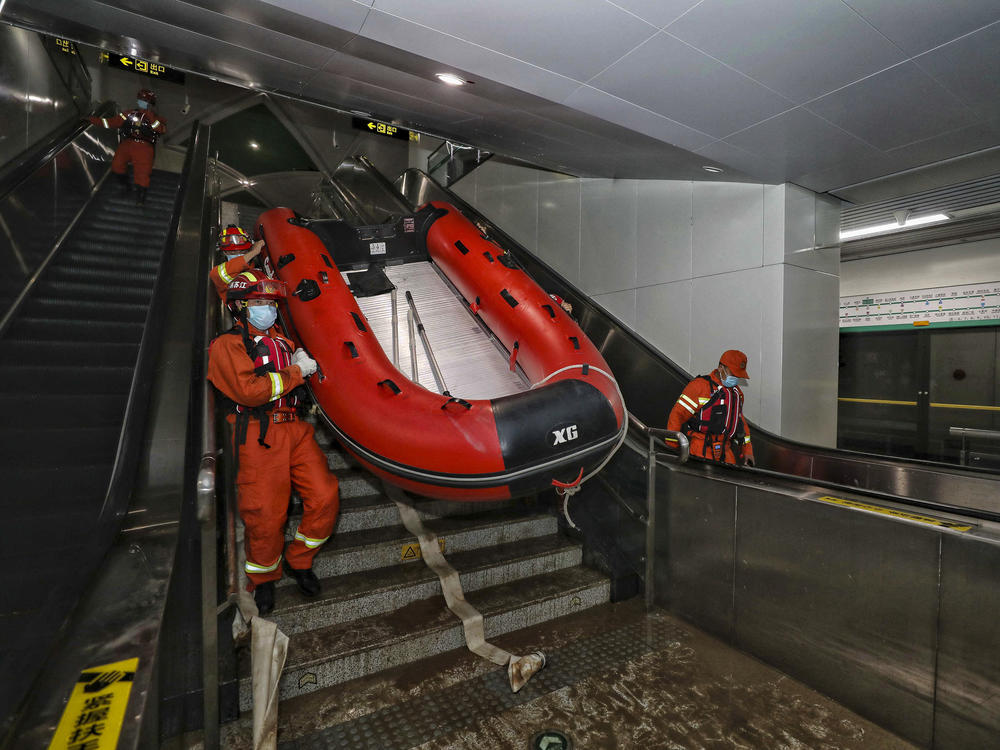 Rescuers carry a boat into the subway in Zhengzhou, China, in July after flash floods trapped passengers underground.