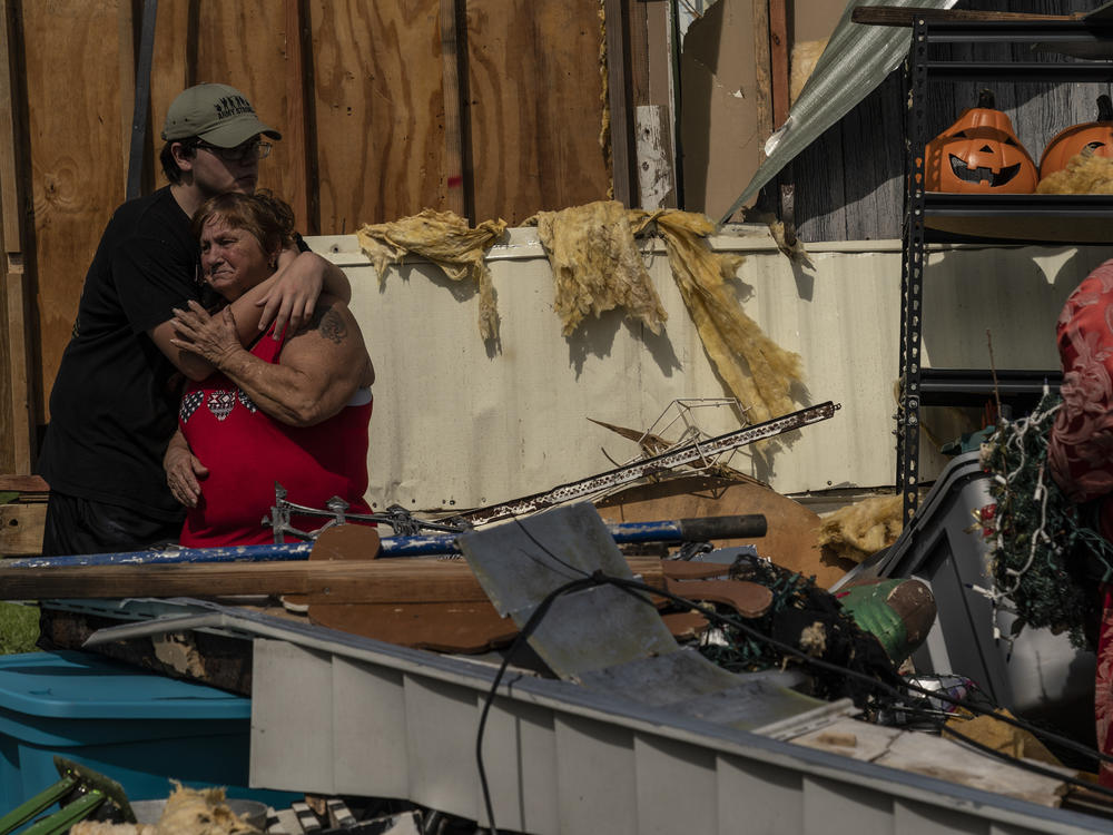 Thomas James Hand comforts Alzile Marie Hand, whose house in Houma, La., was seriously damaged by Hurricane Ida over the weekend.
