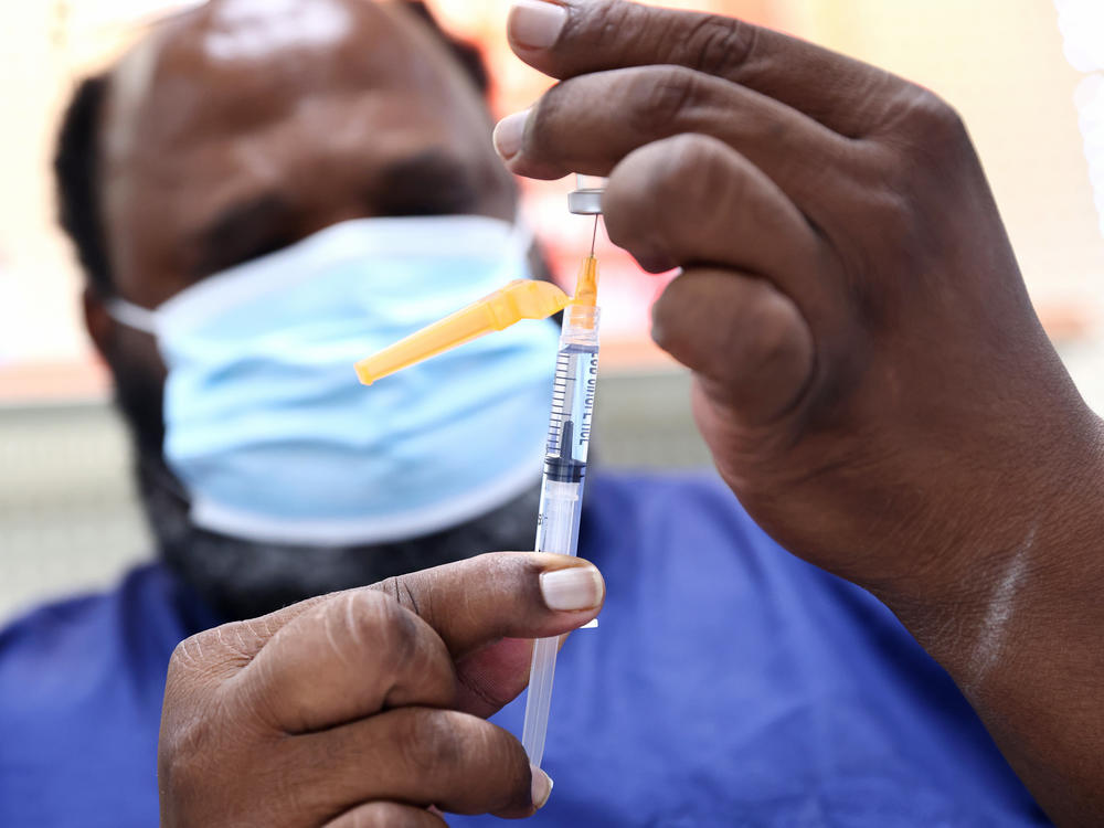 A COVID-19 vaccine dose is prepared at a pharmacy in Baton Rouge, La., on Aug. 17. About 14 million people received their first dose of a COVID-19 vaccine in August.