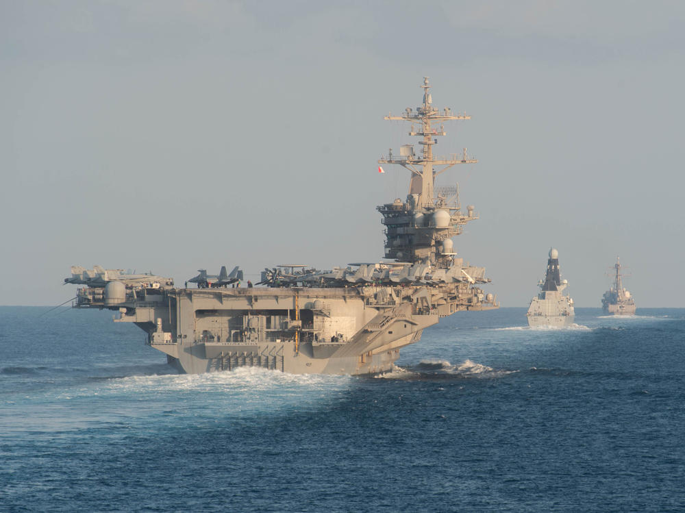 The aircraft carrier USS Abraham Lincoln (left) passes through the Strait of Hormuz in November 2019.