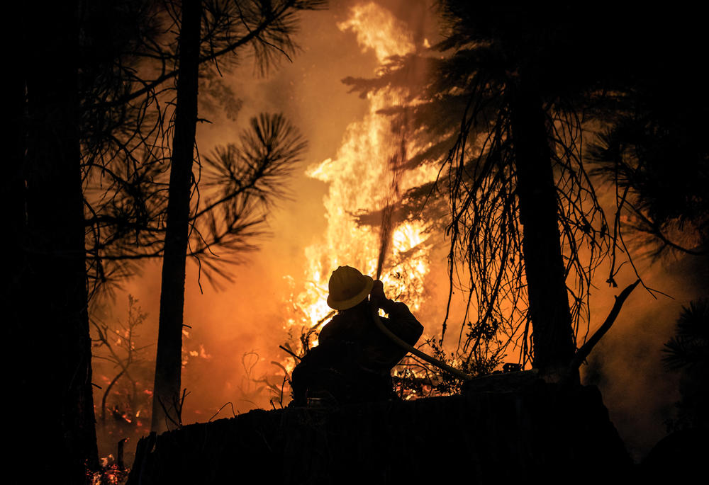 A firefighter with the U.S. Forest Service battles the advancing Caldor Fire on Aug. 28 in Strawberry, Calif.