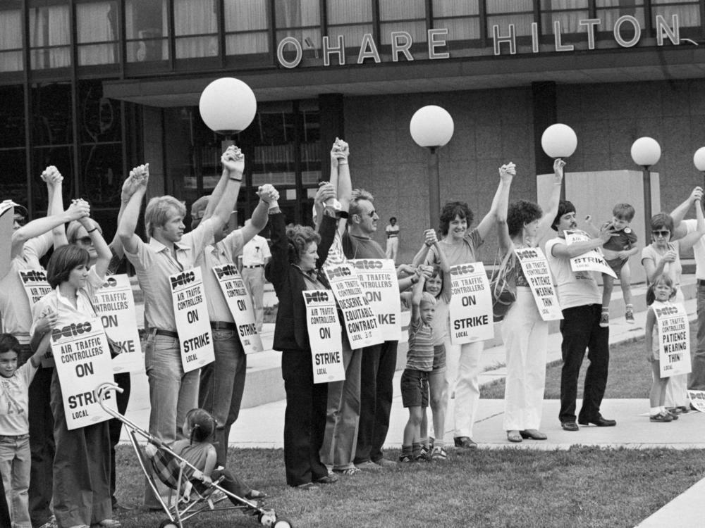 Members of PATCO, the air traffic controllers union, hold hands and raise their arms as their deadline to return to work passes. All strikers were fired on the order of President Reagan on Aug. 5, 1981.