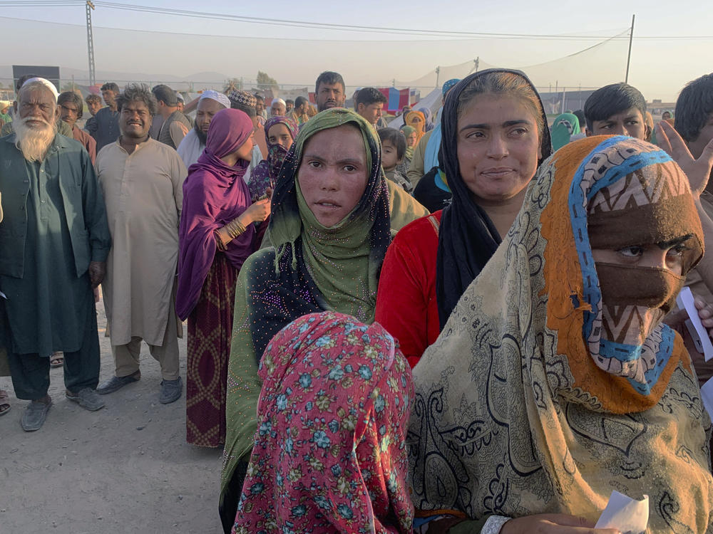 Afghan families gather after leaving their homeland and reaching the Pakistan side of the border, near the town of Chaman on Tuesday. Pakistan and other countries bordering Afghanistan have mostly closed their borders to Afghan refugees, with some exceptions.