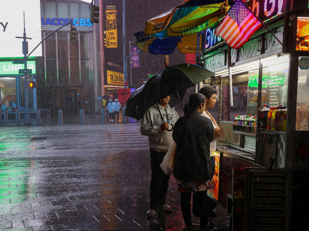People venture out Wednesday in New York's Times Square during the storm.
