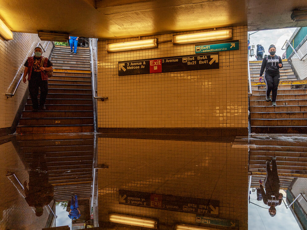 Commuters head into New York's Third Avenue-149th Street subway station on Thursday. Heavy rain from remnants of Hurricane Ida flooded much of the city's subway system. Authorities issued a travel ban and warned residents to avoid stations.