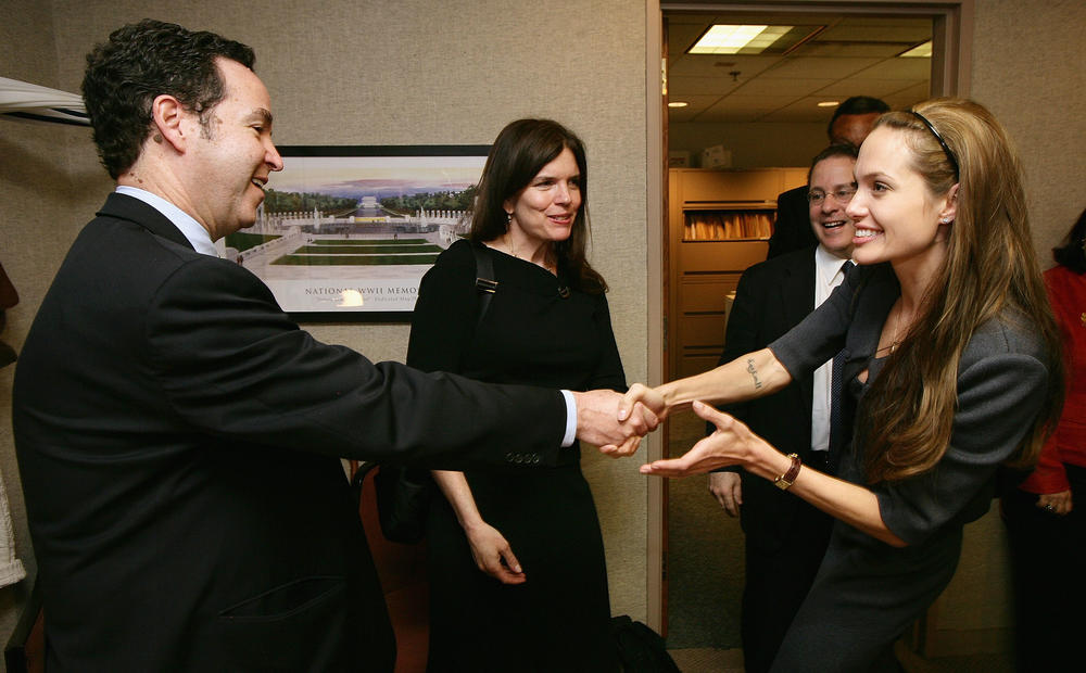 Charny, left, shakes hands with actor and U.N. Goodwill Ambassador Angelina Jolie at a Washington, D.C., event in 2007. At the time, he was on the board of the Cambodian Health Committee.