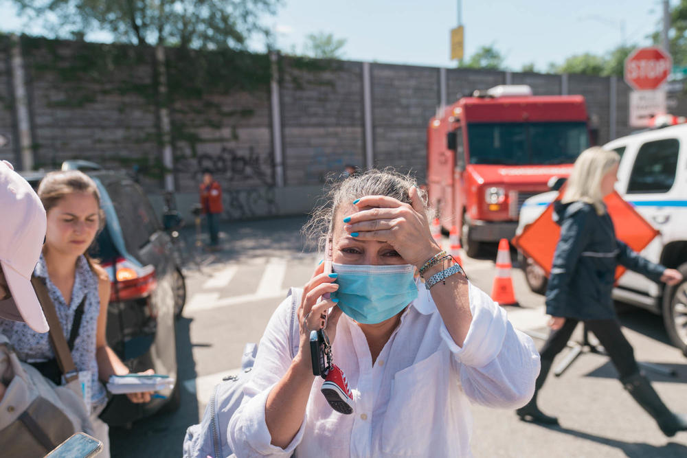 Martha Suarez reacts outside a house where people died in the flooding in Queens, N.Y., on Thursday.