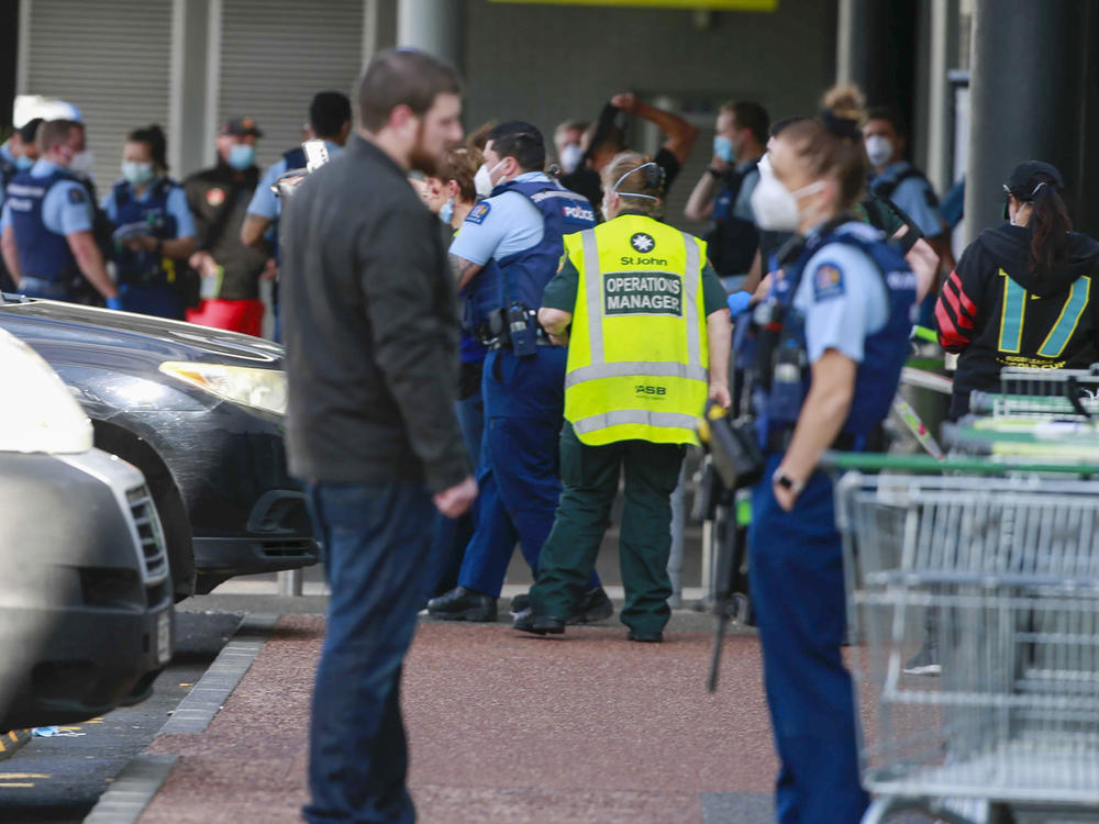 Police and ambulance staff attend a scene outside an Auckland supermarket, Friday, Sept. 3, 2021. New Zealand authorities said Friday they shot and killed a violent extremist after he entered a supermarket and stabbed and injured several shoppers.