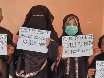 Two family members show the signs they held so U.S. troops could spot them in the crowd at the Kabul airport. 