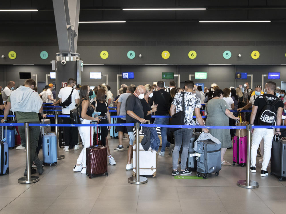 Passengers queue up at Greece's Thessaloniki Makedonia Airport on Sept. 2. Recommendations about physical distancing prove hard to follow at airports — and in the jetway leading to the plane.