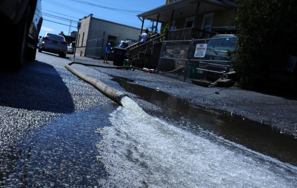 A water pump spits water from a flooded house after a night of high winds and rain from the remnants of Hurricane Ida on Thursday in Mamaroneck, N.Y.