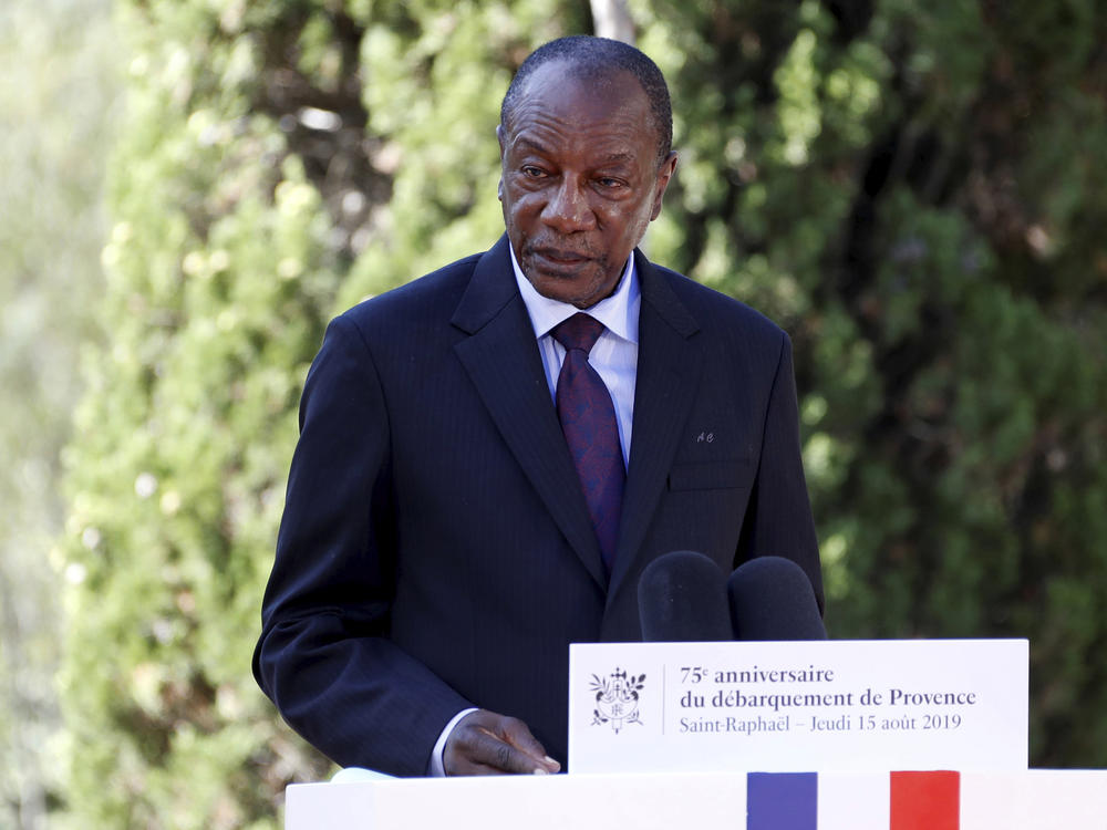 Witnesses say heavy gunfire has erupted near the presidential palace in Guinea's capital and went on for hours. It was not immediately known whether President Alpha Conde, seen above in August 2019, was home at the time the shooting began.