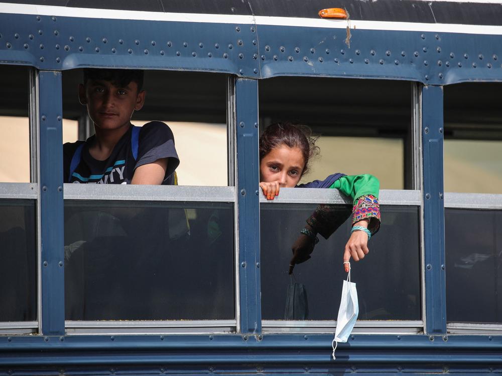 Afghan evacuees sit on a bus at the U.S. air base in Ramstein, Germany, on Aug. 26. Ramstein Air Base, the largest U.S. Air Force base in Europe, has hosted thousands of Afghans.