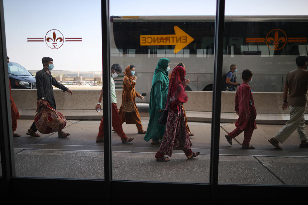 Refugees board buses that will take them to a processing center after they arrive at Dulles International Airport after being evacuated from Kabul following the Taliban takeover of Afghanistan August 27, 2021 in Dulles, Virginia.