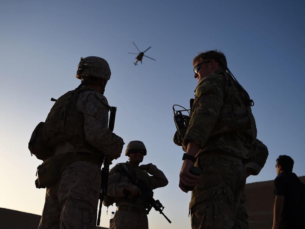 U.S. Marines and Afghan commandos stand together in 2017 at Shorab Military Camp in Helmand province. American ground troops are out of Afghanistan, but war from the air may go on.