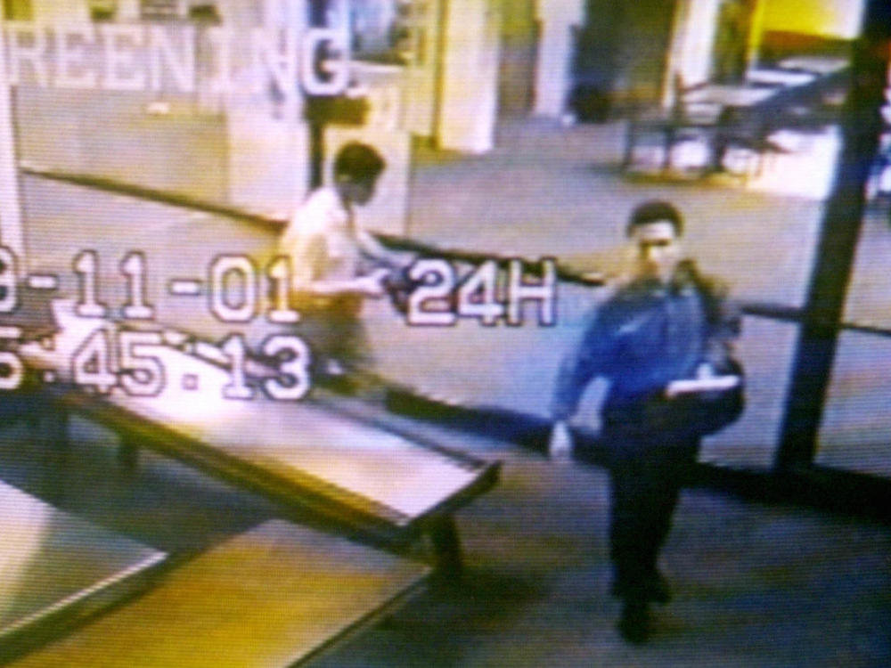Two men identified by authorities as hijackers Mohamed Atta (right) and Abdulaziz Alomari (center) pass through airport security on Sept. 11, 2001, at Portland International Jetport in Maine in an image from airport surveillance tape released on Sept. 19, 2001.